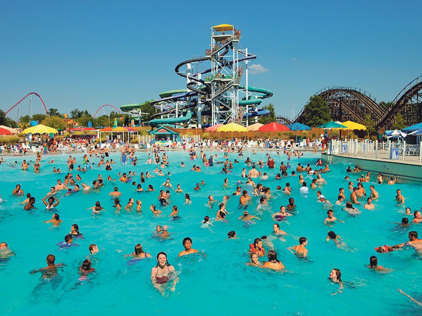Piscina pública con toboganes y personas nadando