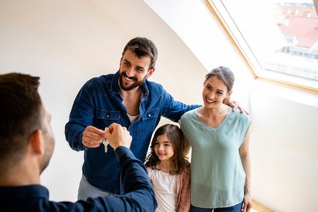Familia feliz recibiendo las llaves de su casa