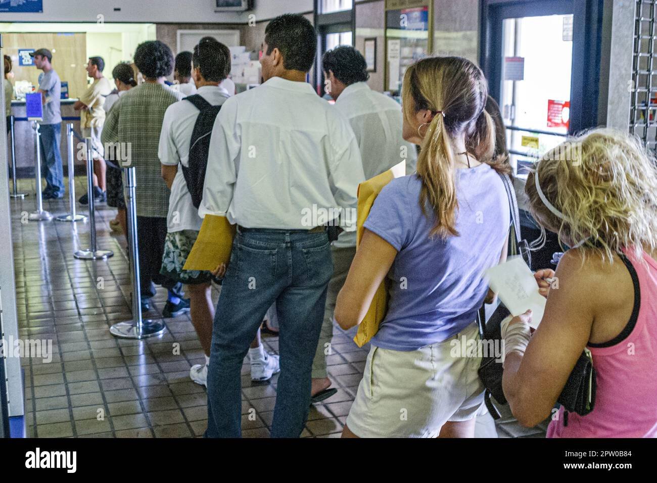 Clientes esperando en larga fila en Correo