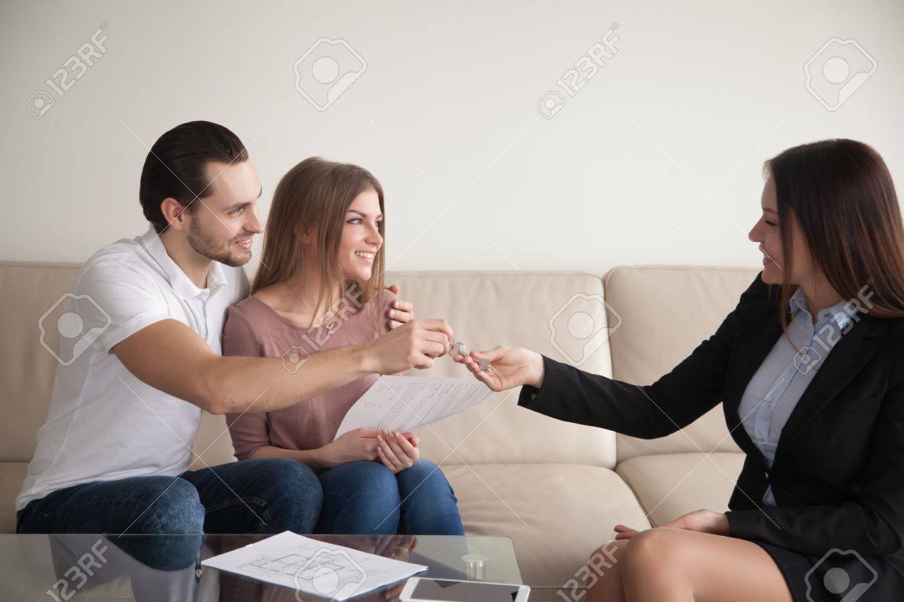 76765683 mujer agente de bienes raices dando claves a los felices propietarios de un apartamento un par de