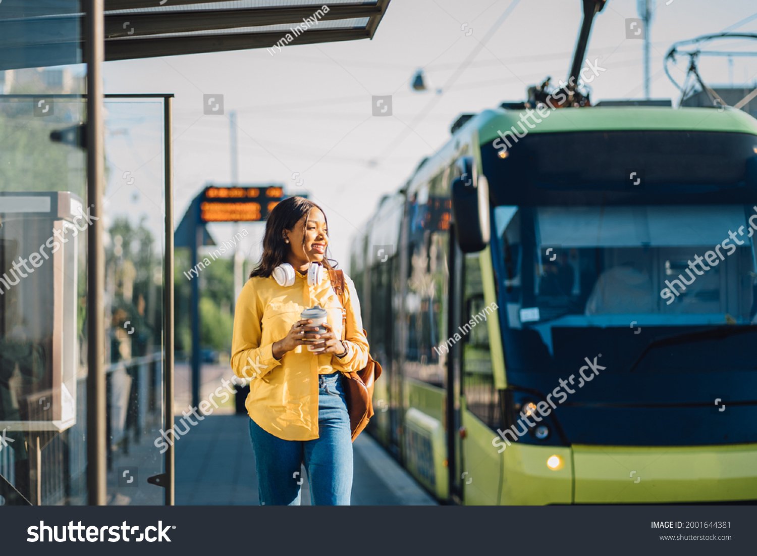 stock photo attractive african american female traveler or student waiting for public transport standing on ram 2001644381