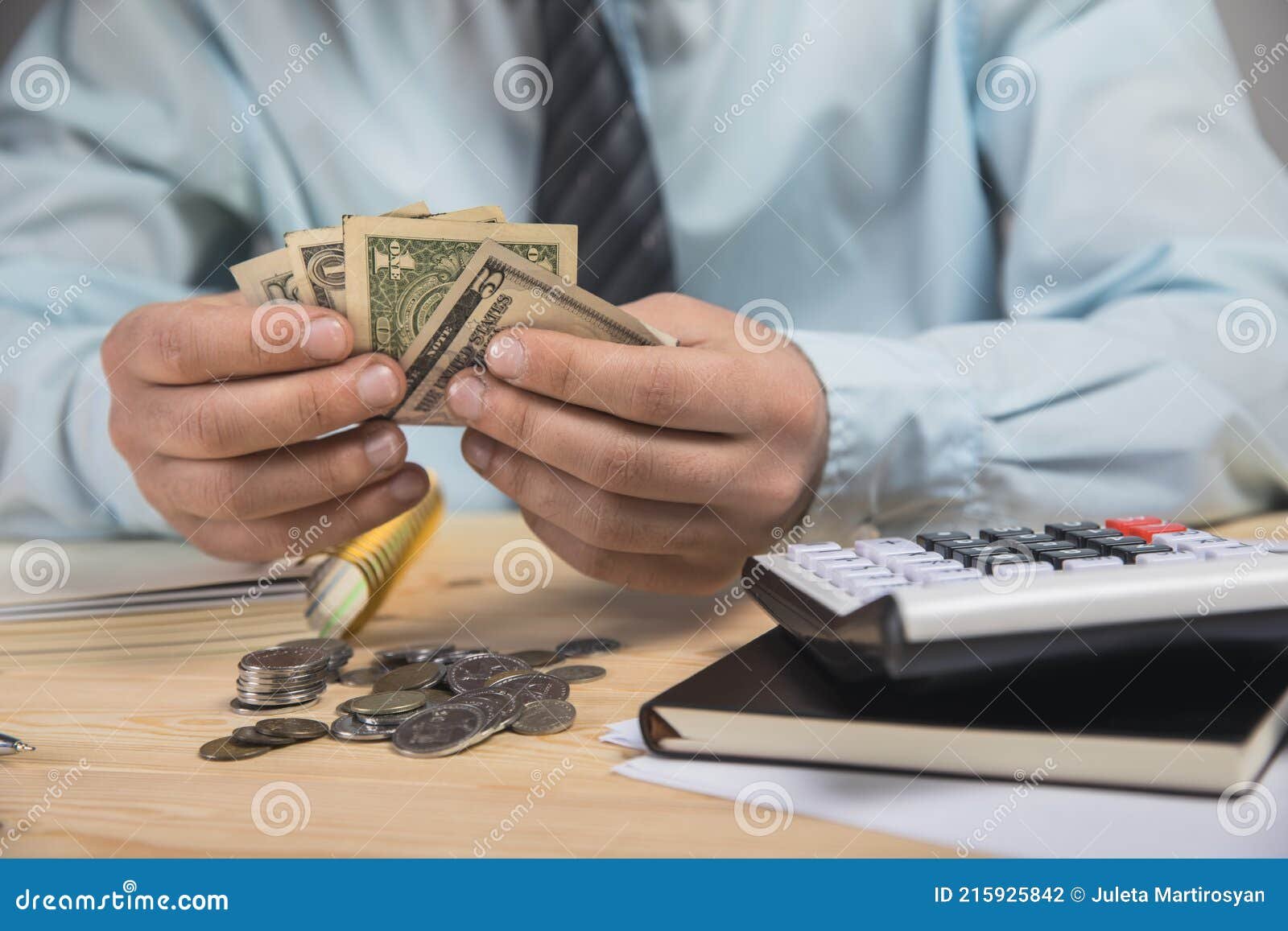 tener dinero en sus manos y contar con una calculadora un hombre sosteniendo contando 215925842
